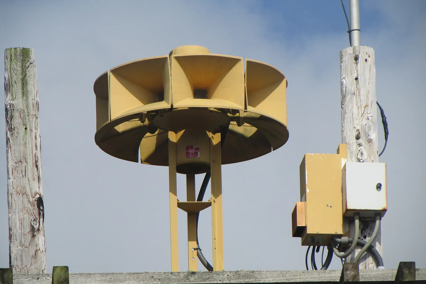 An outdoor warning siren mounted on a pole.